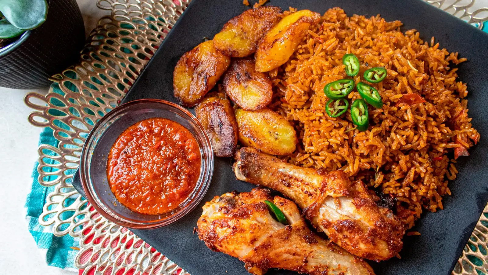 A platter of party jollof rice with chicken and plantain